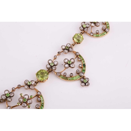 48 - An Edwardian diamond, peridot and demantoid garnet necklace, circa 1910, the floral garland design s... 