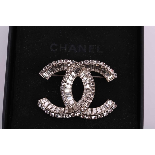 57 - Chanel - an interlocking CC logo brooch encrusted with baguette rhinestones, signed A18V, 5.2 cm wid... 