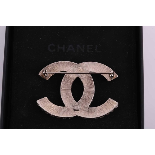 57 - Chanel - an interlocking CC logo brooch encrusted with baguette rhinestones, signed A18V, 5.2 cm wid... 