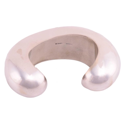 62 - Patricia Von Musulin - a large open cuff bracelet of biomorphic form, polished white metal stamped '... 