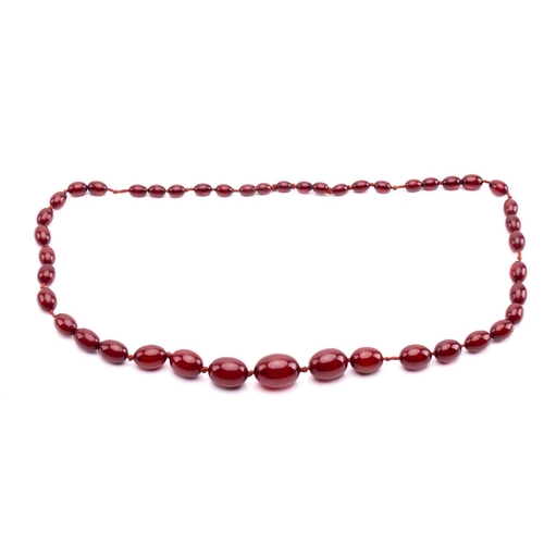 65 - A ruby amber necklace, the oval beads graduating in size, the largest measuring 28mm x 20mm, the nec... 