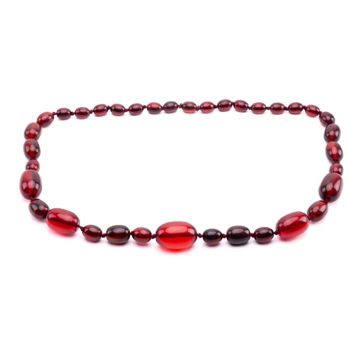 65 - A ruby amber necklace, the oval beads graduating in size, the largest measuring 28mm x 20mm, the nec... 