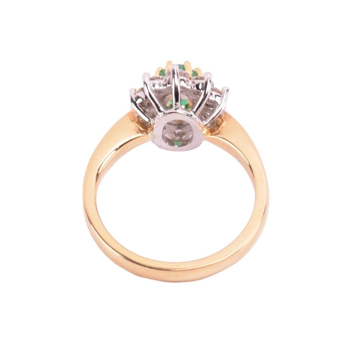78 - An 18 carat gold, emerald and diamond cluster ring; the oval cut emerald in claw mounts above a bord... 