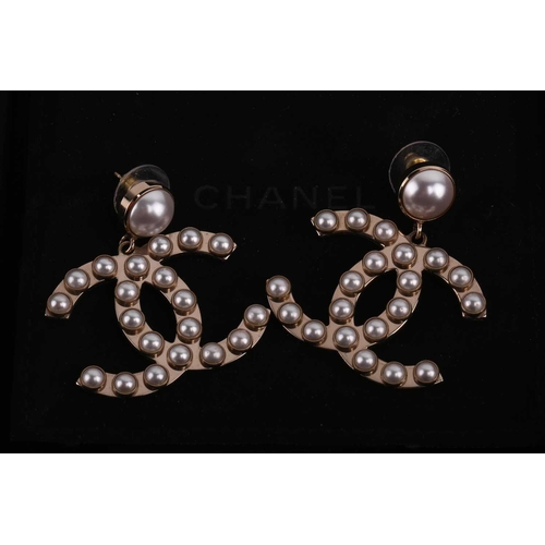 81 - Chanel - a pair of interlocking CC logo drop earrings embellished with faux pearls, ear post and bac... 