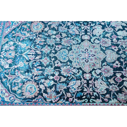 110 - An antique black/blue ground Kerman carpet, with a central star and corners with multiple vines and ... 