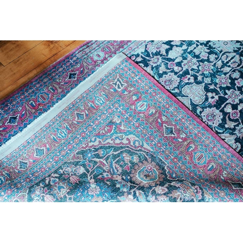 110 - An antique black/blue ground Kerman carpet, with a central star and corners with multiple vines and ... 