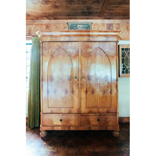 136 - A large 19th century Biedermeier maple two door armoire, the moulded cornice over a pair of lancet a... 