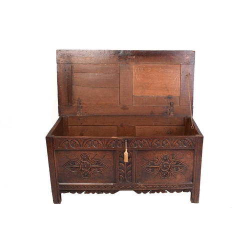 139 - An early 18th-century oak coffer, hinged panel top and a later carved panel front, 126 cm wide x 62 ... 