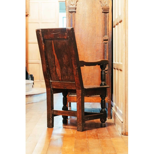 15 - A 17th-century oak wainscot chair, with carved panel back and panel seat, on turned stretched suppor... 