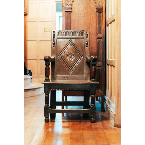 15 - A 17th-century oak wainscot chair, with carved panel back and panel seat, on turned stretched suppor... 