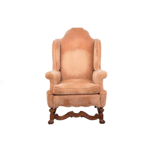 152 - A William & Mary style upholstered wingback fireside chair with a high stepped arched back, roll-ove... 