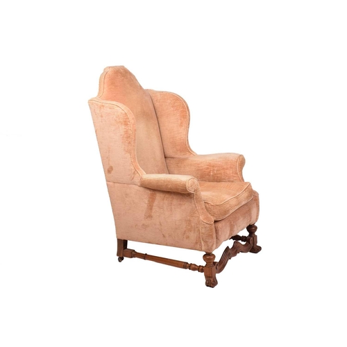 152 - A William & Mary style upholstered wingback fireside chair with a high stepped arched back, roll-ove... 