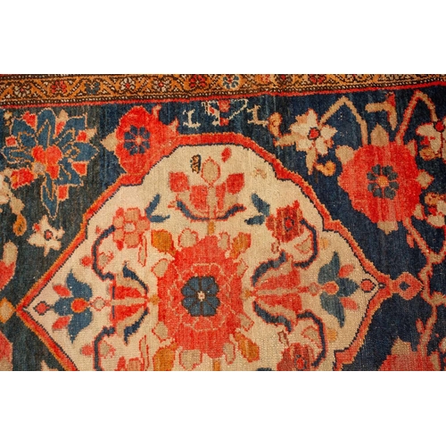 162 - An antique large Mahal runner with dark blue ground a trellis of large flower heads and a central di... 