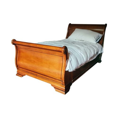 172 - A pair of 'And So To Bed' French-style cherrywood single sleigh beds with scroll ends and sprung sla... 