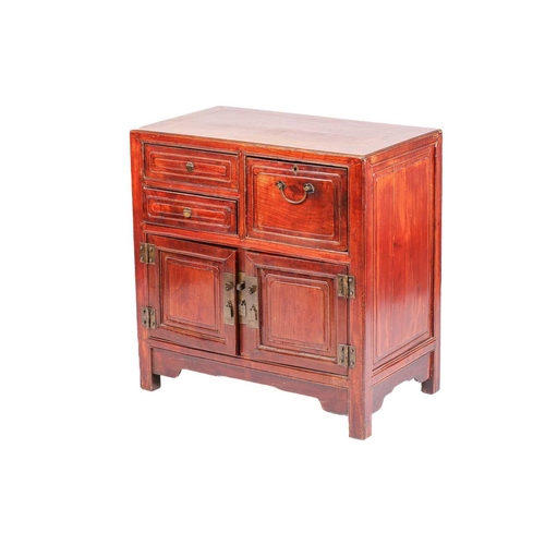 256 - A Chinese hardwood chest, with two short drawers beside a deep drawer over a pair of cupboard doors,... 