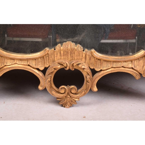 279 - A pair of George II style giltwood wall mirrors, the rectangular plates within frames with floral su... 