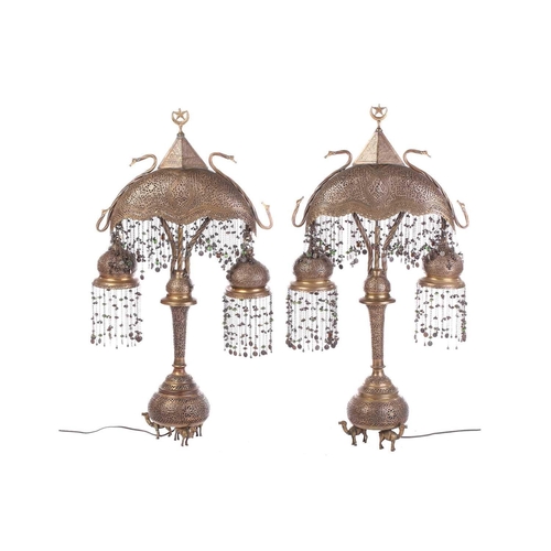 282 - A pair of brass Moroccan table lamps, with pierced and engraved decoration and applied with a silver... 