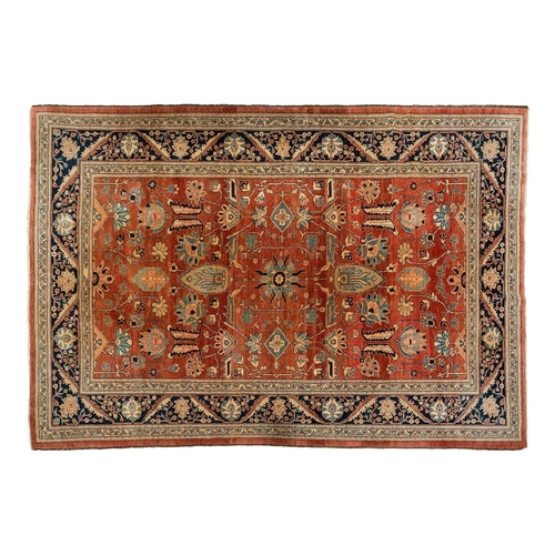 298 - A large brick red ground Serapi-style carpet with central boss and geometric flowers and shrubs, wit... 