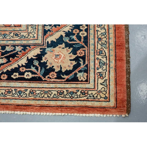 298 - A large brick red ground Serapi-style carpet with central boss and geometric flowers and shrubs, wit... 