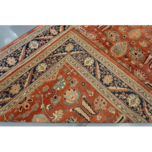 298 - A large brick red ground Serapi-style carpet with central boss and geometric flowers and shrubs, wit... 