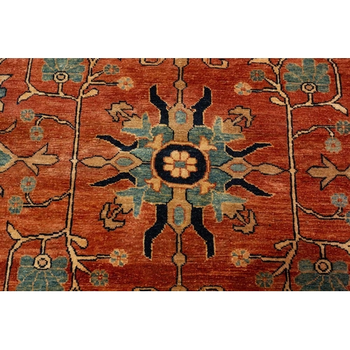 298 - A large brick red ground Serapi-style carpet with central boss and geometric flowers and shrubs, wit... 