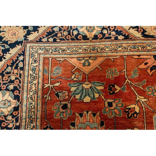 298 - A large brick red ground Serapi-style carpet with central boss and geometric flowers and shrubs, wit... 