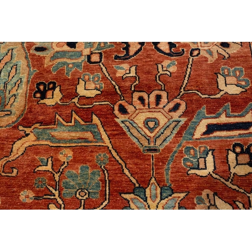 298 - A large brick red ground Serapi-style carpet with central boss and geometric flowers and shrubs, wit... 