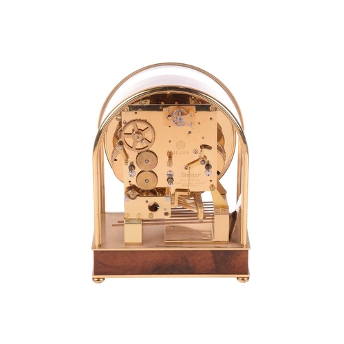 303 - A Kieninger 8-day contemporary mantel clock, with brass arched and glazed case, with skeletal dial c... 