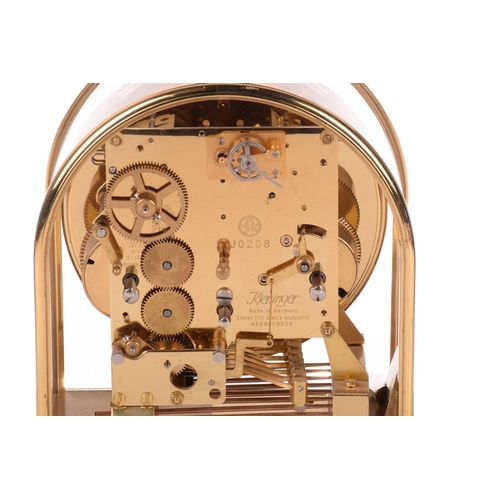 303 - A Kieninger 8-day contemporary mantel clock, with brass arched and glazed case, with skeletal dial c... 