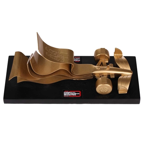 369 - A presentation model, in abstract form, of an F1 racing car, gilt metal, given as a gift by Formula ... 