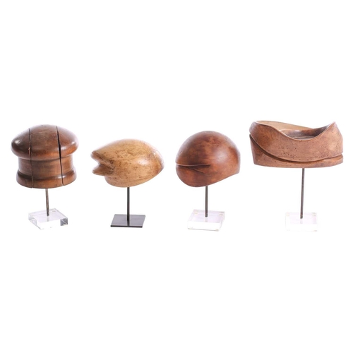 371 - Four hardwood vintage hat lasts, of varying shapes, on display stands, tallest 34.5 cm on the stand ... 