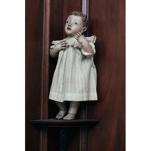 43 - An 18th-century Spanish carved and polychromed wood figure of a cherub, with inset glass eyes, and a... 