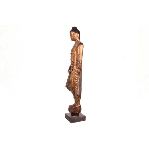 244 - A Burmese carved and gilt wood standing Buddha in varada mudra, 19th century, set with jewels and mi... 