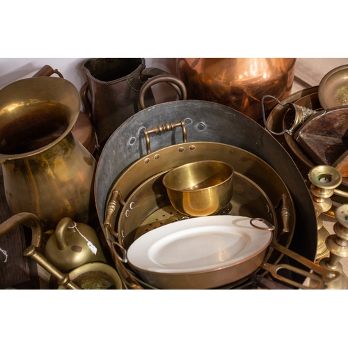 77 - A large quantity of brass, pewter and copper items, to include pans, bowls, a milk churn, candlestic... 