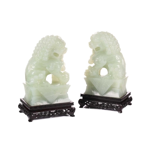 118 - A pair of Chinese bowenite carved dogs of foo, each on a conforming wooden display stand, each 20 cm... 