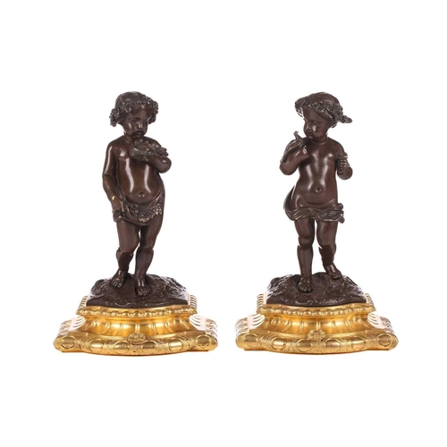 244 - A pair of bronze figures of standing putti holding a dove and a nest, on ormolu cabochon design socl... 