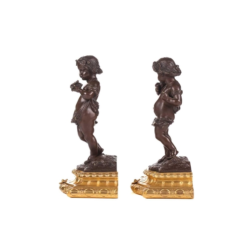 244 - A pair of bronze figures of standing putti holding a dove and a nest, on ormolu cabochon design socl... 