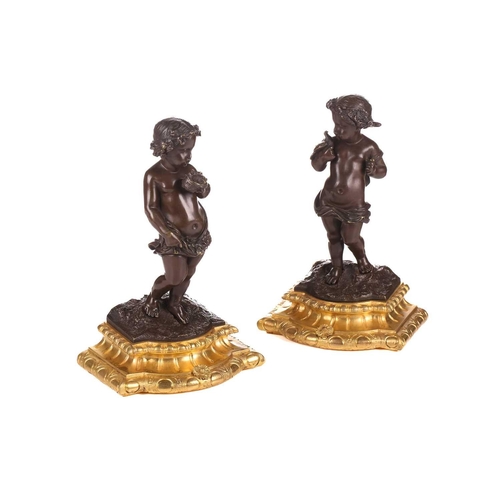 244 - A pair of bronze figures of standing putti holding a dove and a nest, on ormolu cabochon design socl... 