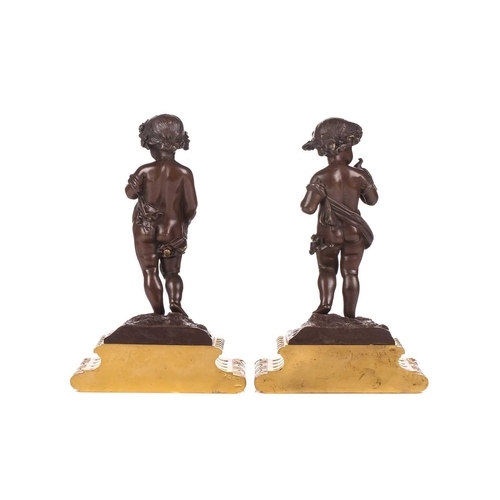 244 - A pair of bronze figures of standing putti holding a dove and a nest, on ormolu cabochon design socl... 