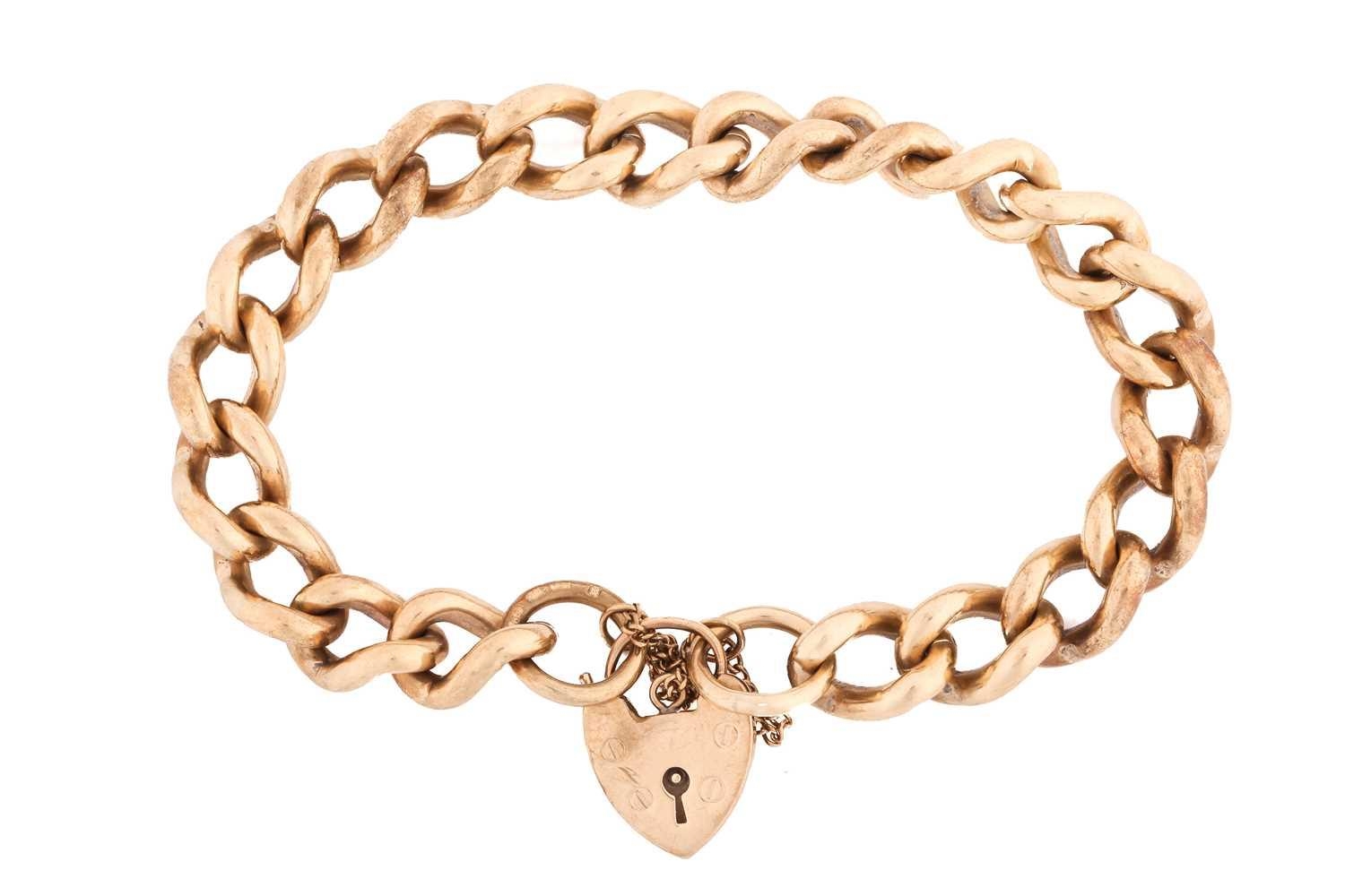 A 9ct yellow gold heavy curb link and padlock bracelet, featuring 10mm ...