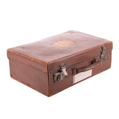 308 - A vintage brown leather travelling case, containing a quantity of musical instrument accessories, co... 