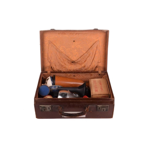 308 - A vintage brown leather travelling case, containing a quantity of musical instrument accessories, co... 