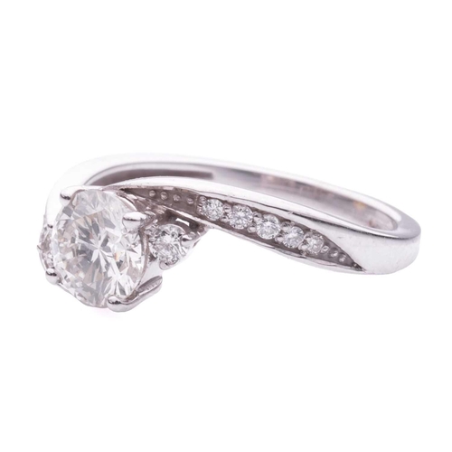 159 - A Diamond set crossover engagement ring, featuring a round brilliant cut diamond with a stated weigh... 