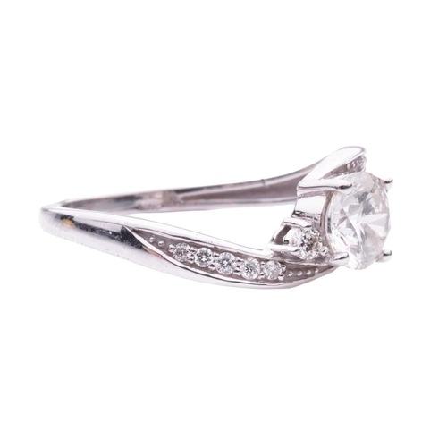 159 - A Diamond set crossover engagement ring, featuring a round brilliant cut diamond with a stated weigh... 