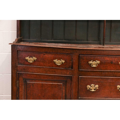 166 - A George III oak cupboard dresser and Delft rack, the base with a central bank of drawers flanked by... 