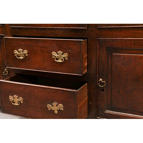 166 - A George III oak cupboard dresser and Delft rack, the base with a central bank of drawers flanked by... 