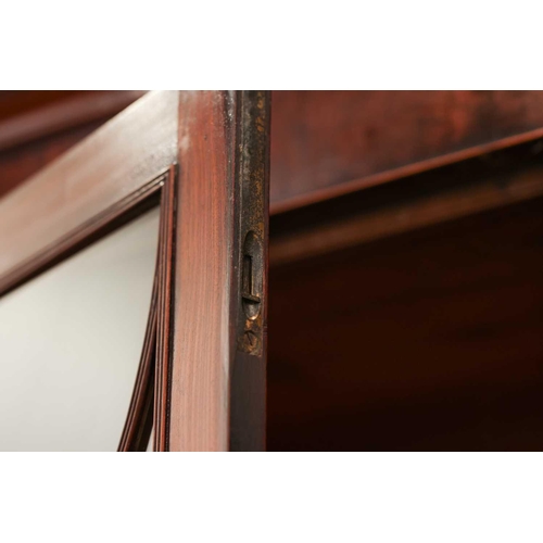 183 - A George IV mahogany secretaire bookcase, the upper section with a pair of eliptical glazed doors, t... 