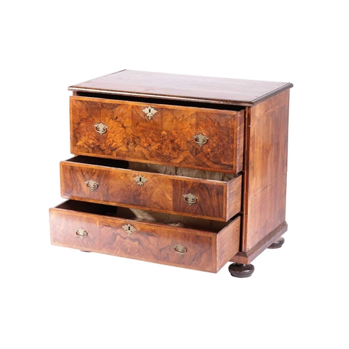 200 - A William & Mary walnut chest of three long drawers, the parquetry top with the central quartered pa... 