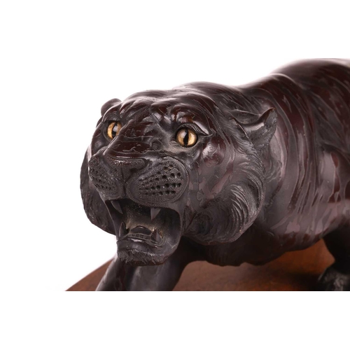 3 - A Japanese bronze okimono of a stalking tiger, first half of the 20th century, with inset glass eyes... 