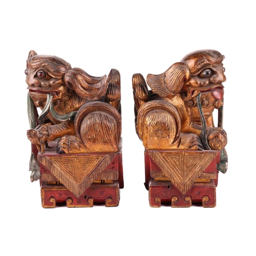 35 - A large pair of Chinese red lacquered and parcel-gilt wood architectural Dog of Foo finials, probabl... 